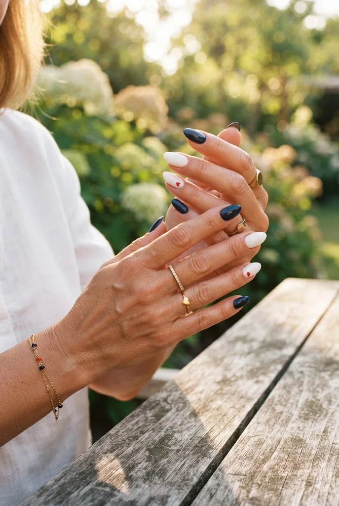 Patriotic Fourth of July nails with tiny red heart accents.